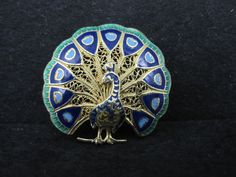 This gorgeous vintage brooch is 1960s New Old Stock - Imported from Portugal. It is gold gilt over sterling with beautiful enamel detailing. Measurements: 1 1/8 by 1 3/16 inches Condition: Excellent - some with original tags Gold Brooches With Peacock Design As Gift, Peacock Brooch, Inlay Jewelry, Purple Labradorite, Labradorite Ring, Amethyst Bracelet, Coral Turquoise, Vintage Brooch, Garnet Rings