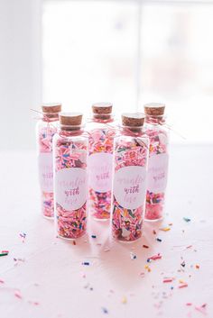 four bottles filled with sprinkles on top of a table