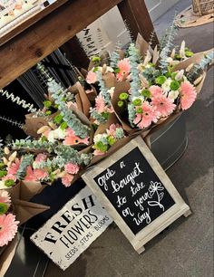 flowers and signs are on display in a store's flower shop, including succulents