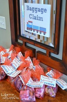 bags of baggage sitting on top of a wooden table next to a framed sign that says baggage claim