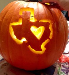 someone carving a pumpkin with the shape of an arrow