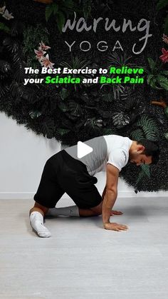 a man kneeling down on the ground in front of a wall with plants and words