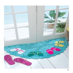 a pair of flip flops are on the floor next to a crocheted rug