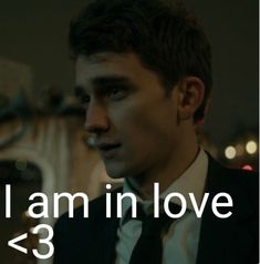 a man wearing a suit and tie with the words i am in love