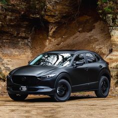 a black mazda cx - 5 parked in front of a cliff