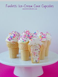 three ice cream cones with sprinkles and white frosting are on a plate