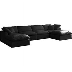 a black sectional couch with pillows on the top and bottom part, in front of a white background