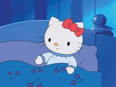 a hello kitty sitting on top of a bed in a room with blue walls and curtains