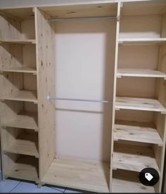 an empty closet with wooden shelves and white walls