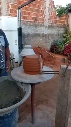 a man standing next to a bucket filled with cement