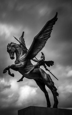 a statue of a man riding on the back of a horse next to a bird