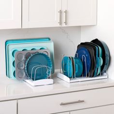 there are plates and cups in the holder on the kitchen counter, next to each other