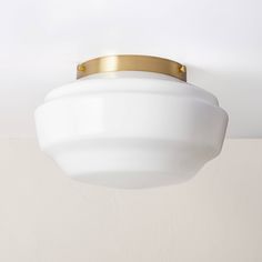 a white ceiling light with a gold trim on the top and bottom part of it