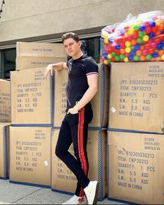 a man standing next to stacks of boxes with gummy balls on top of them