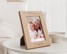 a wooden photo frame sitting on top of a table next to a cup and saucer