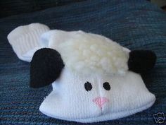 a white and black sheep hat sitting on top of a blue blanket