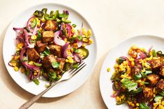 two white plates filled with food next to each other on top of a beige table