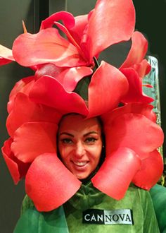 a woman wearing a large red flower hat