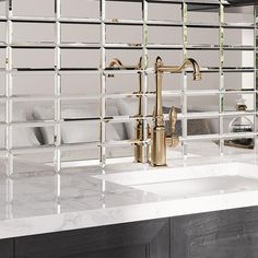 a bathroom sink sitting under a mirror next to a counter top with two faucets