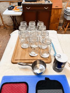 there are many mason jars and spoons on the table with utensils next to them