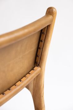 a close up of a wooden chair with buttons on it's armrests