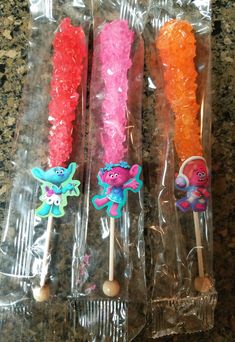 three toothbrushes in plastic wrappers on a counter