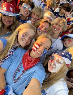 a group of people with their faces painted in the colors of the american flag are posing for a photo