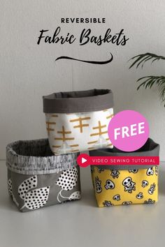 four fabric baskets sitting on top of a table next to a potted plant with the text reversible fabric baskets