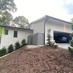 a car is parked in the garage on top of a pile of wood mulch