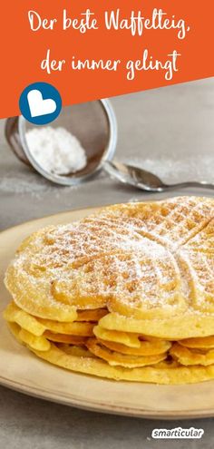 pancakes on a plate with powdered sugar and spoons in the background text reads, der beste wafflelien der ummer geling