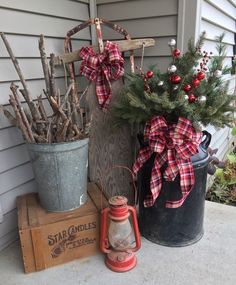 two buckets filled with christmas decorations on top of a wooden crate next to a tree