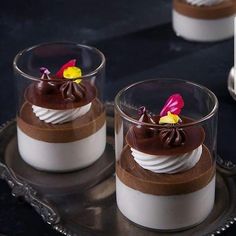 two desserts are sitting on a silver tray