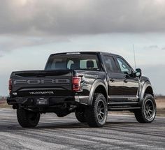 a black truck is parked on the road