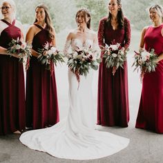 a group of women standing next to each other holding bouquets and smiling at the camera