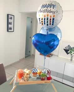 a blue heart shaped balloon sitting on top of a table next to a plate of food