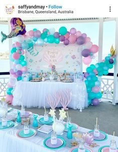 an under the sea themed birthday party with balloons, cake and dessert table set up