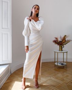 Fabric: Satin Cotton 50%, Polyester 50% Sweetheart neckline Puffed sleeves Long sleeves Thigh slit Dress length: 135 cm/ 53,14 in Sleeve length: 70 cm/ 27,55 in Colors: White, Sky-Blue, Dusty Pink, Grey Satin White Dress With Sleeves, Satin Dinner Gowns Classy Style, White Satin Dress Outfit, Fall Bridal Shower Outfit For Bride, Winter Rehearsal Dinner Outfit, Formal Winter Wedding Guest Dress, Courthouse Wedding Dress Ideas, Winter Courthouse Wedding, Dinner Gowns Classy Style