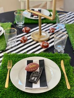 a football themed table setting with black and white striped napkins, silverware, and gold cutlery