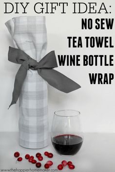 a wine bottle wrapped in a plaid cloth with a glass of wine next to it and the words diy gift idea no sew tea towel wine bottle wrap