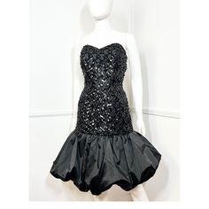 "1980s vintage black sequined strapless dress by Patricia. Strapless black lace dress with a boned bodice. Black sequins are sewn onto the black lace which also has gold metallic woven through it. Sweetheart neckline. Nipped waist and fitted hips. Voluminous black satin bubble hem. Lined in black acetate. Nylon zipper at the back.  { LABEL- FABRIC- TAG SIZE } Patricia Acetate  Labeled Size 8- refer to measurements { MEASUREMENTS } Shown on a 5'8\" Mannequin with 33\" Bust- 25\" Waist- 35\" Hips