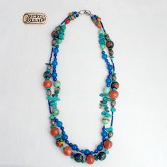 This one of a kind multi-strand necklace is made of turquoise, apple coral, lapis lazuli, blue chalcedony, african trade beads and highlighted with silver beads A versatile piece that can be worn to the office, with jeans or layered for that bohemian chic look. sterling clasp 28 1/2"L Artisan Blue Beaded Necklaces With Gemstone Beads, Artisan Blue Beaded Necklace With Natural Stones, Artisan Blue Gemstone Beaded Necklaces, Artisan Blue Gemstone Beaded Necklace, Artisan Blue Turquoise Necklace With Colorful Beads, Bohemian Blue Beads With Natural Stones, Artisan Blue Gemstone Beads, Bohemian Blue Natural Stone Beads, Blue Double Strand Bohemian Turquoise Necklace