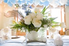 a vase filled with white flowers on top of a table