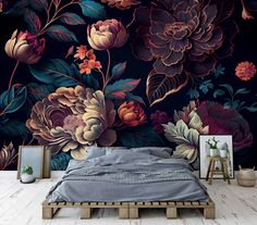 a bed sitting in front of a wall with flowers on it