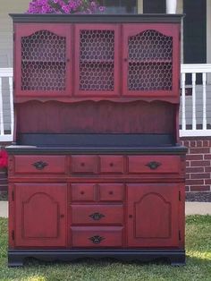 an old dresser is painted red and black