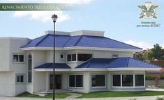 a large white house with blue roof tiles