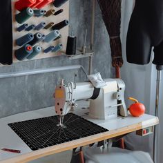 a sewing machine sitting on top of a table next to an orange and black object