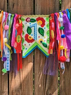 a colorful banner hanging on a wooden fence