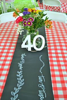 the table is decorated with red and white checkered tablescloths, flowers in a vase