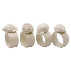 three white ceramic rings with seashells on them