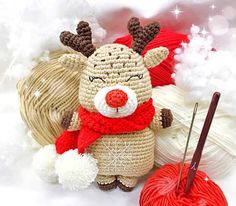 a crocheted reindeer with a red scarf next to yarn and a knitting needle